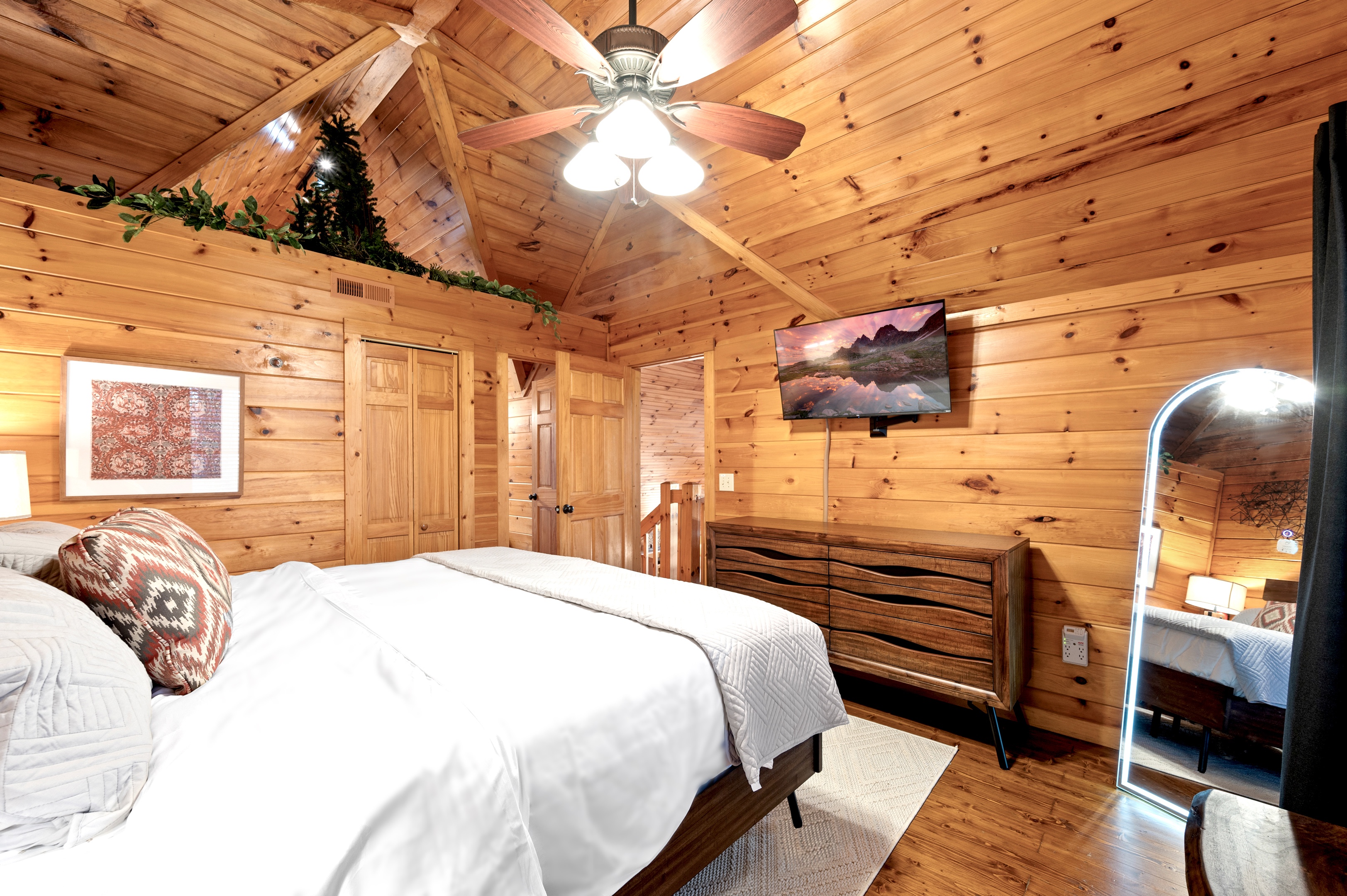 Cozy bedroom with full-length mirror and smart TV