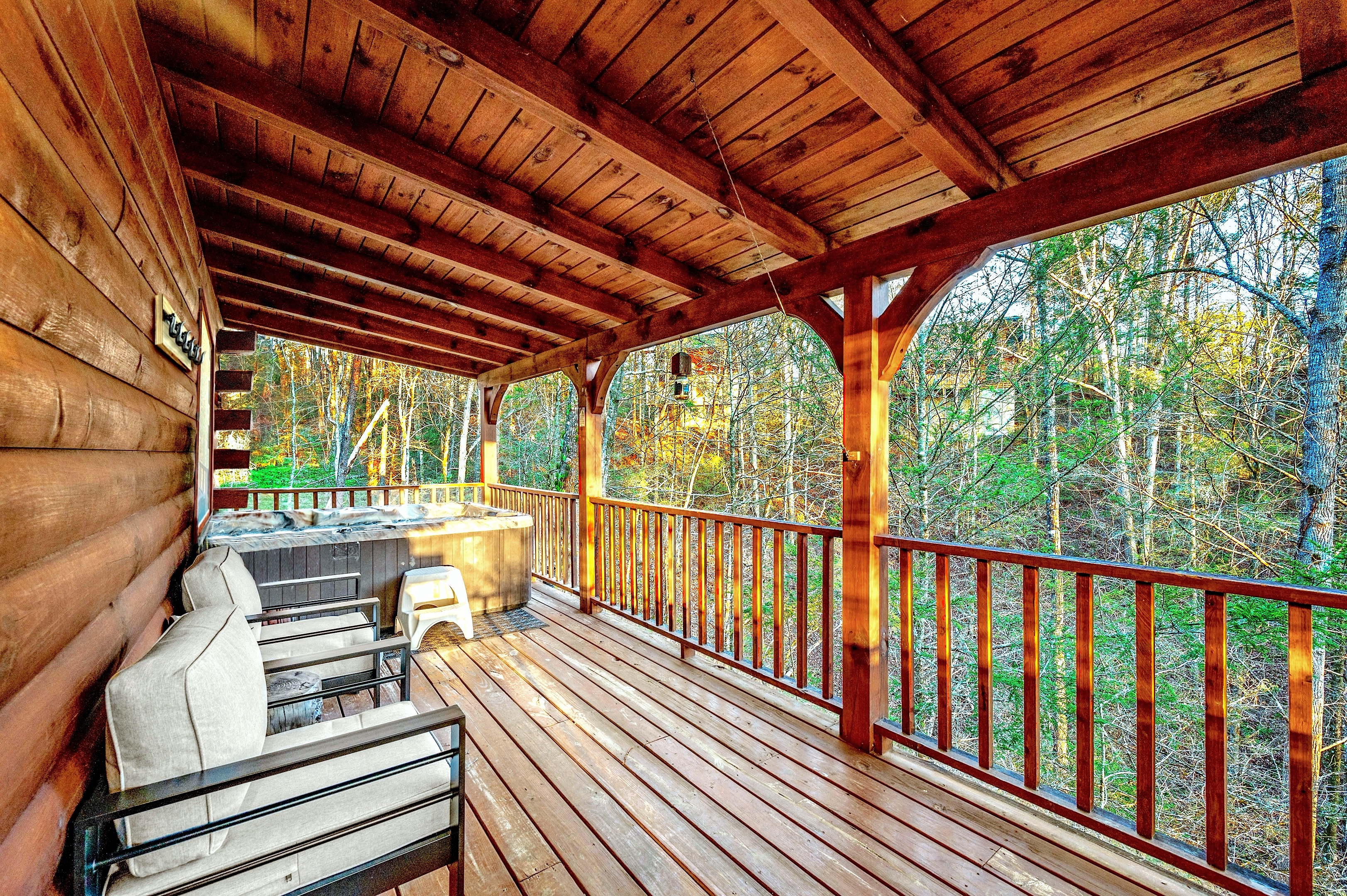 Spacious covered deck with hot tub and forest views
