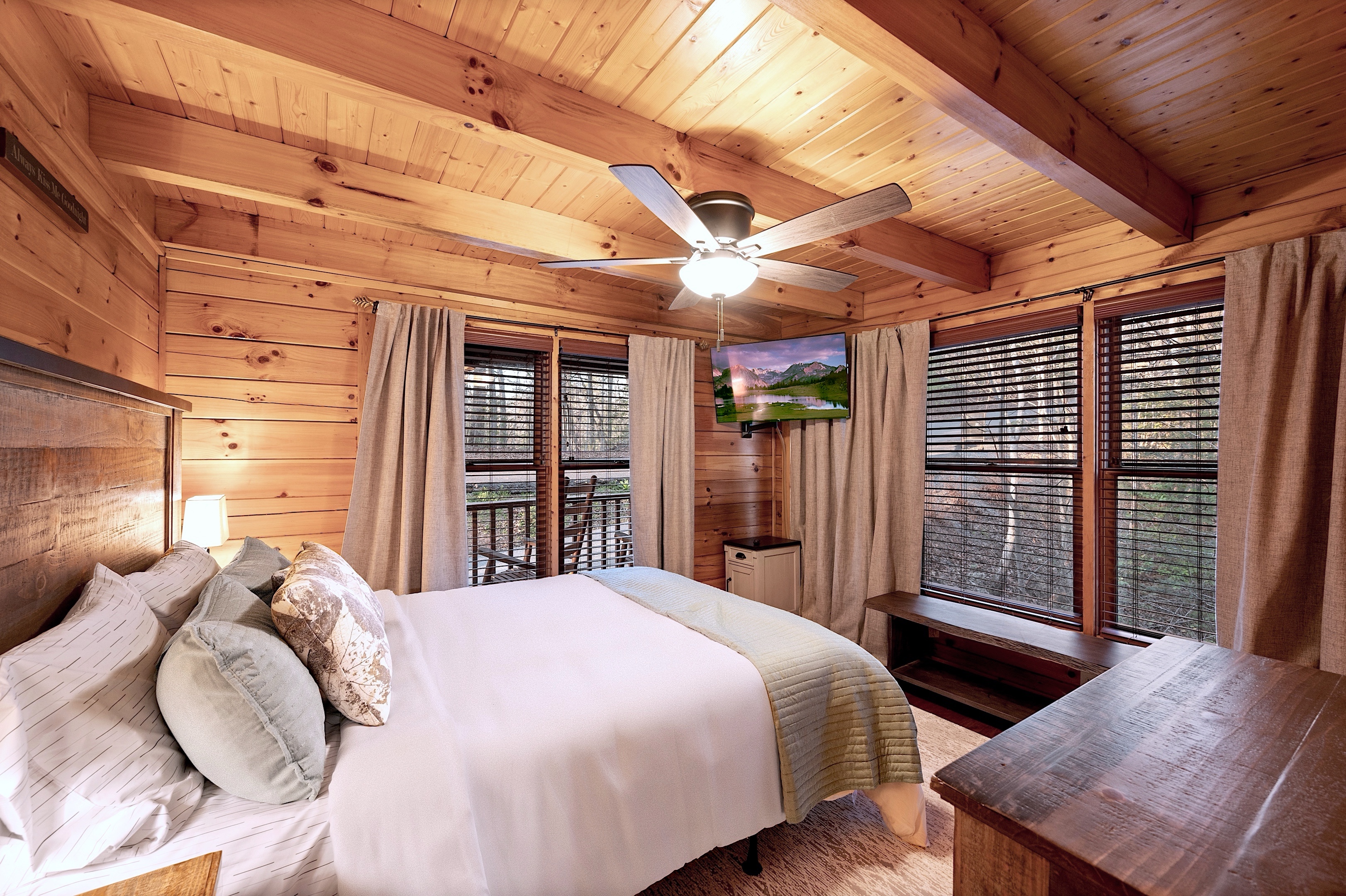 Master bedroom with large windows overlooking forest