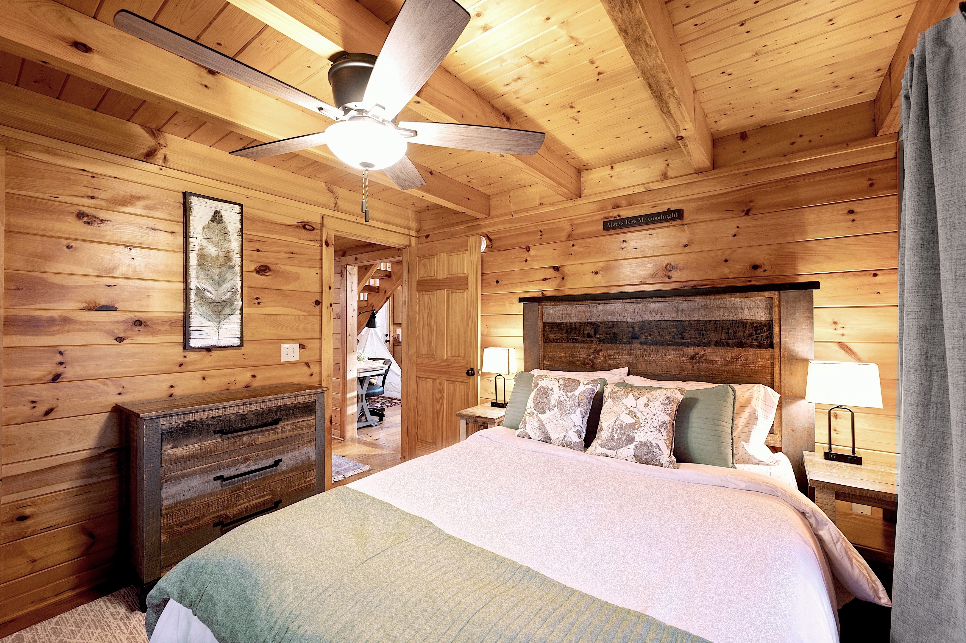 Luxurious master bedroom with king bed and warm wood walls