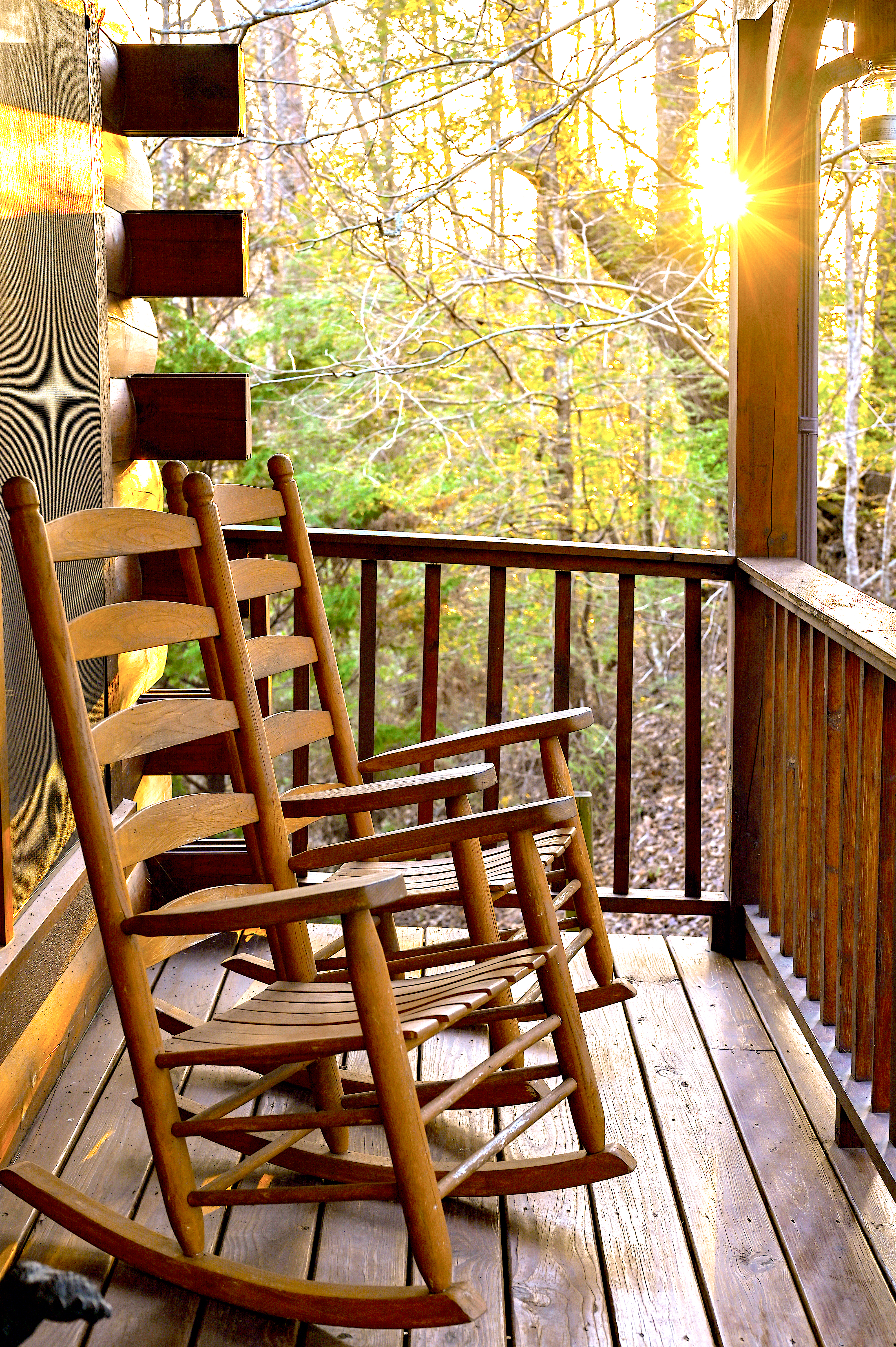 Wooden rocking chairs on porch at golden hour sunset